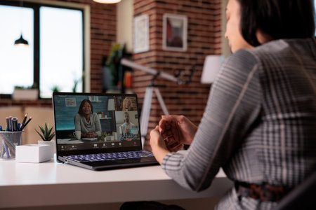 Female freelancer meeting on remote videoconference with people on laptop webcam, chatting on...