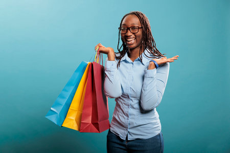Excited and cheerful woman smiling with mouth wide open after buying stylish and fashionable store goods at mall. Beautiful and happy young lady joyful after purchasing clothing articles at discount.の写真素材