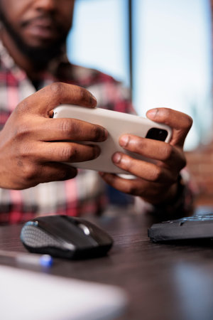 Young man playing online video games on virtual technology, holding smartphone to have fun wth game...