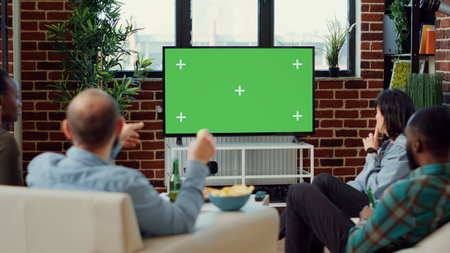 Multiethnic group of friends looking at greenscreen to watch movie or film on tv channel program....