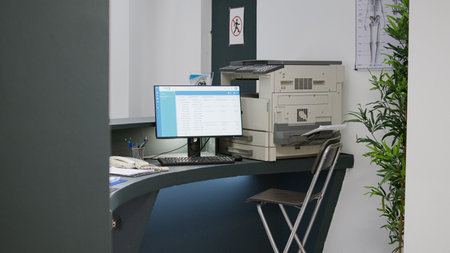 Hospital reception counter with medical appointment reports on computer desktop. Empty registration desk at health center to help and treat patients with checkup visit consultations.の写真素材