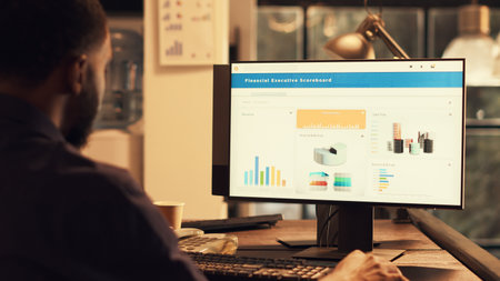 Office worker analyzing financial shares and data on computer, working with company project to create professional report. Using online network app with marketing for presentation.の写真素材