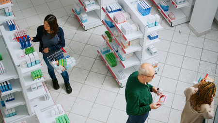 Diverse clients waiting in line to pay for medication at pharmacy shop counter, having prescription...