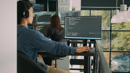 Asian system engineer working with html script on computer screen, using terminal window. Software...