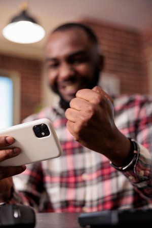 Male gamer winning video games play on smartphone website at home, playing online competition and...