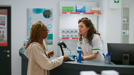 African american customer buying medicine products and paying with credit card, using contactless payment to buy medicaments from pharmacy shop. Sitting at drugstore counter to buy pills.の写真素材