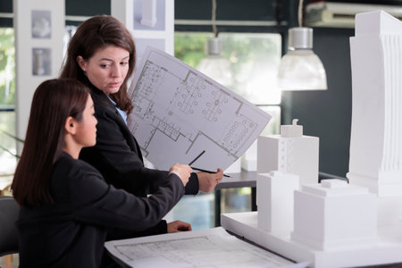 Architect and engineer holding blueprint, discussing construction project sketch, working with cad...