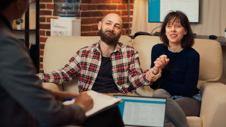 Man and woman holding hands after making peace, enjoying reconciliation at counseling session with...