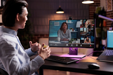 Male employee attending videocall business meeting on computer, talking to people on online videoconference chat. Chatting on remote teleconference call with webcam at home, freelance job.の写真素材