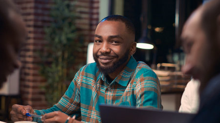 African american employee smiling portrait in business meeting, coworkers talking at boardroom...