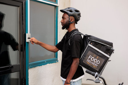 Office food delivery service courier waiting for customer outdoors, pressing company building...