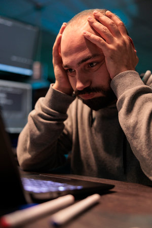 Frustrated tired developer programming server database, feeling stressed about artificial intelligence failure at night. Overworked programmer feeling sad working with html it code, workload.の写真素材