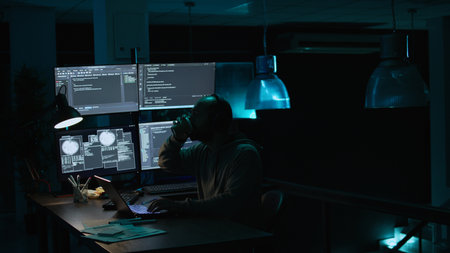 Young IT coder yawning and working on new interface, feeling sleepy late at night. Tired software...