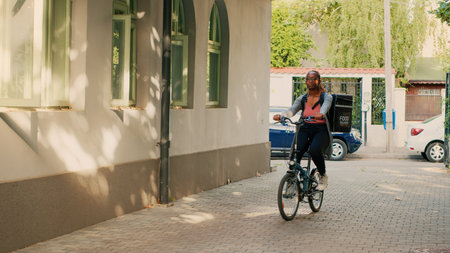 Food delivery service worker carrying backpack on bike, working as carrier to give takeaway meals to...