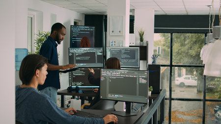 Diverse team of database developers analyzing code on terminal window, working with html script and artificial intelligence. System engineers talking about app developing interface.の写真素材
