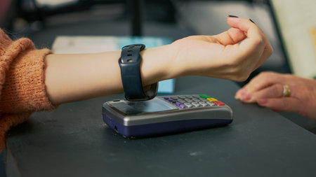 Customer buying pharmaceutical products with smartwatch, using nfc payment at pos terminal on...