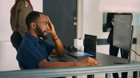 Software programer writing program code to develop database system in front of computer, displaying artificial intelligence algorithm. Developer coding html script on terminal window. Handheld shot.の写真素材
