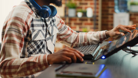 Post production house employee editing photos on touchscreen display, using tablet and stylus pen in...