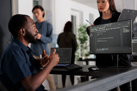Diverse group of web developers analyzing html code and comparing data script in big data office room. Cloud programers working on system interface algorithm in development company.の写真素材