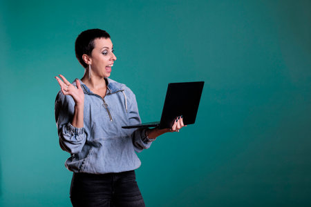 Smiling woman greeting remote team discussing business strategy during videocall meeting conference...