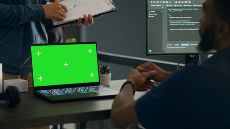 Database admins analyzing source code and greenscreen display on computer to develop software algorithm in busy space. Cloud programers working with chromakey template isolated copyspace.の写真素材