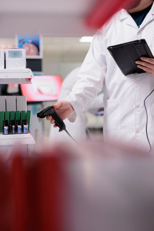 Worker scanning healthcare products with store scanner while verifies the prescription and checks for any potential drug interactions in pharmacy. Medicine support service and conceptの写真素材