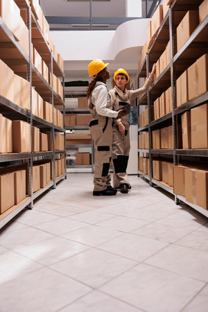 Freight distribution center employees scanning boxes before transportation. Two woman warehouse...