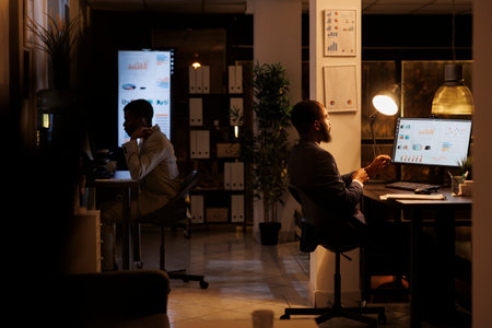 Corporate worker working overhours at marketing strategy, analyzing company statistics graph....