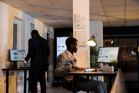 Entrepreneur looking at financial graphs report on computer, planning company investment typing...