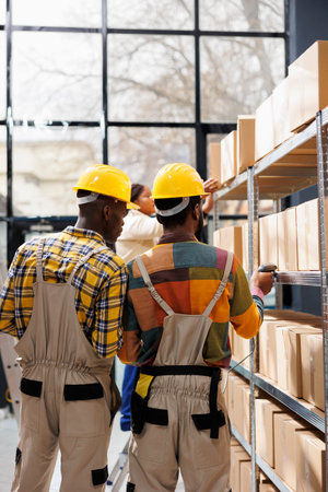 African american storehouse employees analyzing goods in stock using barcode scanner. Merchandise...
