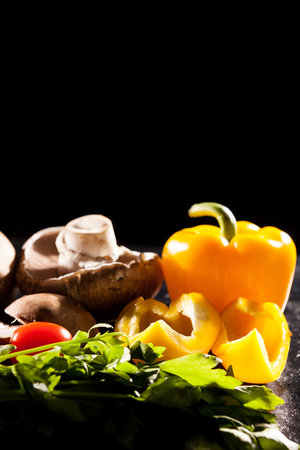Artistic image of different type of healthy organic vegetables on dark background in studio photoの写真素材