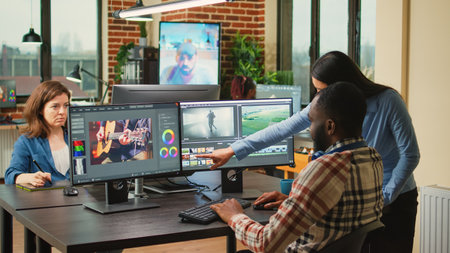 Diverse videographers editing creative film montage on software, brainstorming ideas to improve...