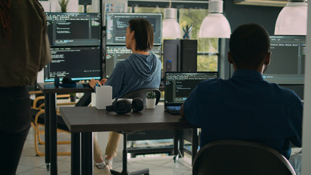 African american it engineer writing code on laptop and computer, analyzing html script on terminal...