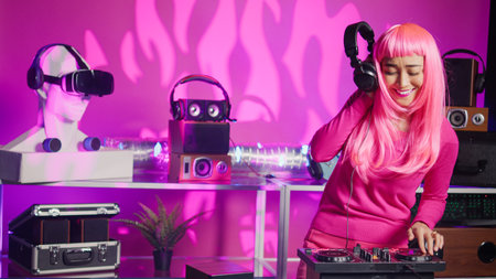 Artist playing electronic song using professional turntables, enjoying performing music in night club. Performer using cutting-edge technology to remix music, having fun playing techno songの写真素材