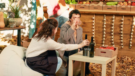 Group of women meeting at street fair to taste organic wine, tasting natural fresh produce at table. Happy people enjoying products sampling at food market festival, drink wine. Tripod shot.の写真素材