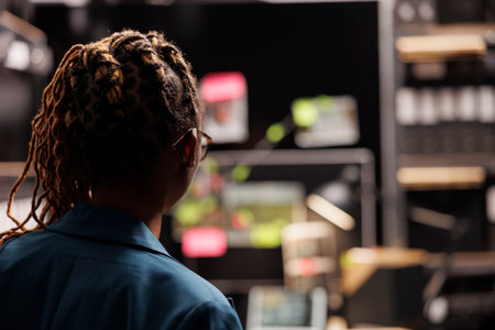Private detective standing in working overtime in agency office. African american woman investigator studying crime clues connection scheme on wall board back view close upの写真素材