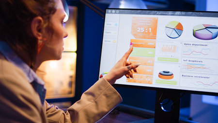 Advisor agent analyzing statistics graphs in startup office and using computer to plan financial...