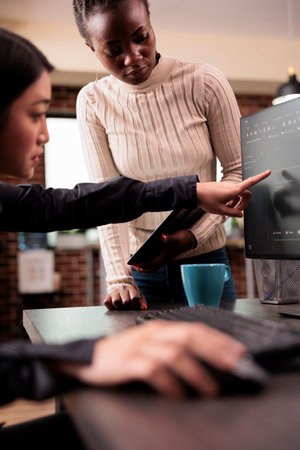 Team of software developers talking about source code running on computer, working with cloud computing terminal window. Engineers working with user interface to develop new security firewallの写真素材