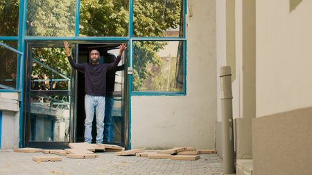 Pizzeria female courier dropping pizza boxes pile at customer front door, being clumsy and running. Bad delivery service, takeout restaurant employee trying to catch falling packages. Tripod shot.の写真素材