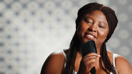 Young woman singing with hair brush in studio and showing confidence, embracing imperfections in skincare campaign. Beauty model feeling confident and funny, promoting self acceptance.の写真素材