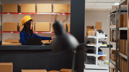 Young women preparing merchandise for shipment, putting retail products in boxes and working on...