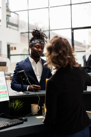 African american customer talking with store manager at cash register, discussing sale cupon during...