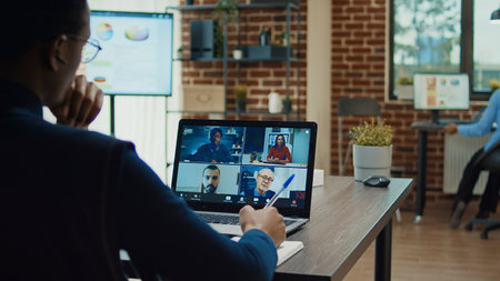 Office worker attending business meeting on videocall in boardroom, using online teleconference to...