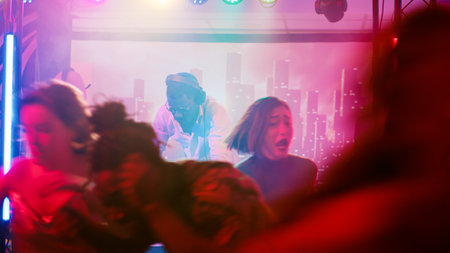 Party interrupted by police officers, cheeful people at nightclub running away from law enforcement. Group of persons being afraid and panicking after seeing police lights in discotheque.の写真素材