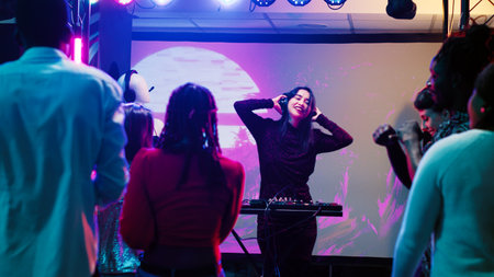 Diverse friends partying at nightclub, having fun together with live performance show on club dance...