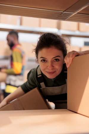 Smiling employee working with cardboard boxesの写真素材