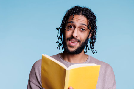 Man holding book and talking about novel plot portraitの写真素材
