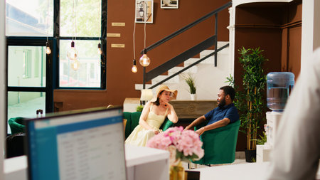 Hotel staff talking to guests in lobbyの写真素材