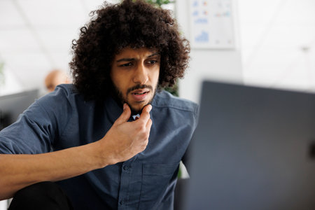 Entrepreneur thinking about sales increasing while working on laptop