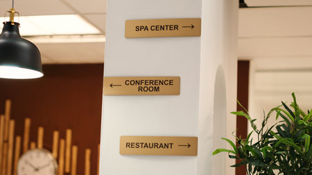 Empty stylish business accommodationlobby interior with luxurious deluxe conference room, spa center and restaurant amenities. Close up of hotel facilities plaque signs on resort lounge wallの写真素材